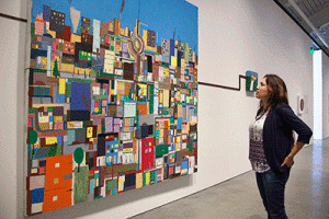 In BAMPFA, senior Brenda Romero admires a Chris Johanson painting, “Cityscape with House & Gray Energy.” (UC Berkeley photo by Brittany Murphy)