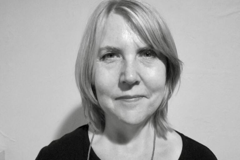 Grayscale portrait of an older woman with light hair and a faint smile.