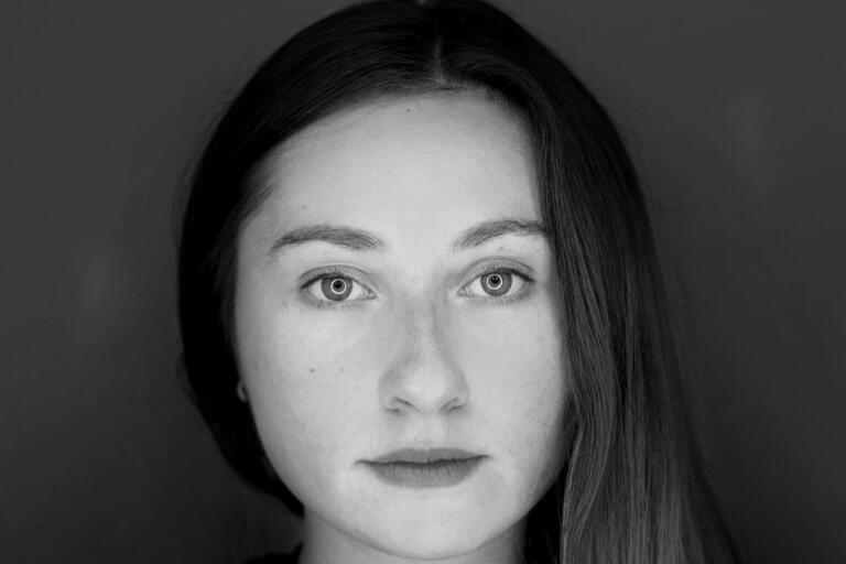Black and white portrait of a young woman with long, straight hair and a neutral expression.