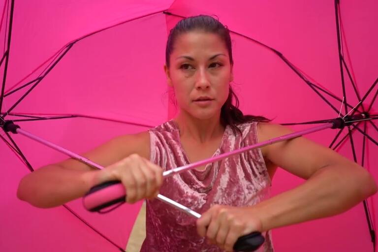 Person under two large pink umbrellas