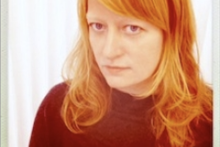 Close-up portrait of a person with light red hair.