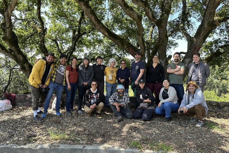 Group of Indigenous artists/scholars in front of tree