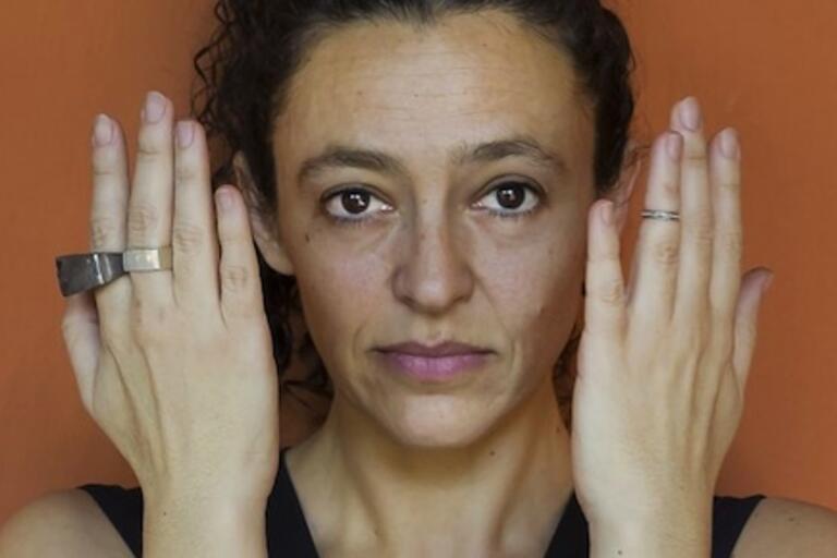 A woman with her hands on her face, expressing a mix of emotions and contemplation.