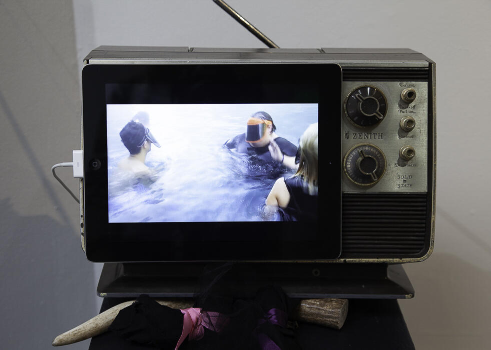 television with image of two people against a white wall