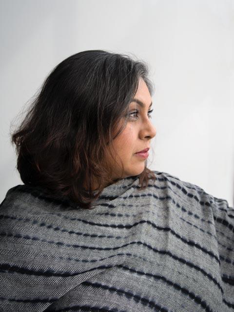 Woman in profile, wearing a gray shawl with black design on it