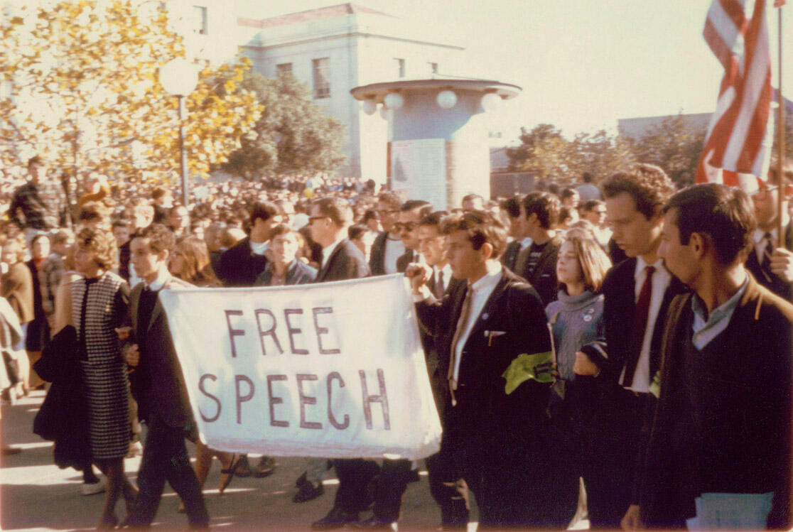 People march with a "free speech" banner
