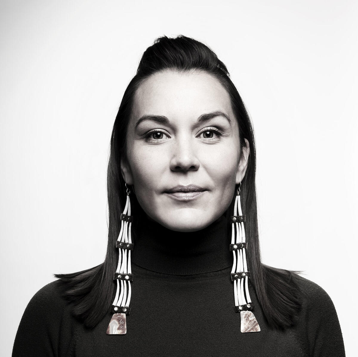 Black and white headshot of Cara Romero, wearing long earrings