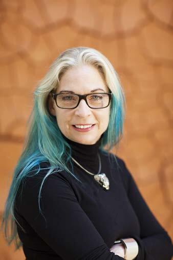 Headshot of Cheryl Haines, she has teal hair, glasses, and is wearing black
