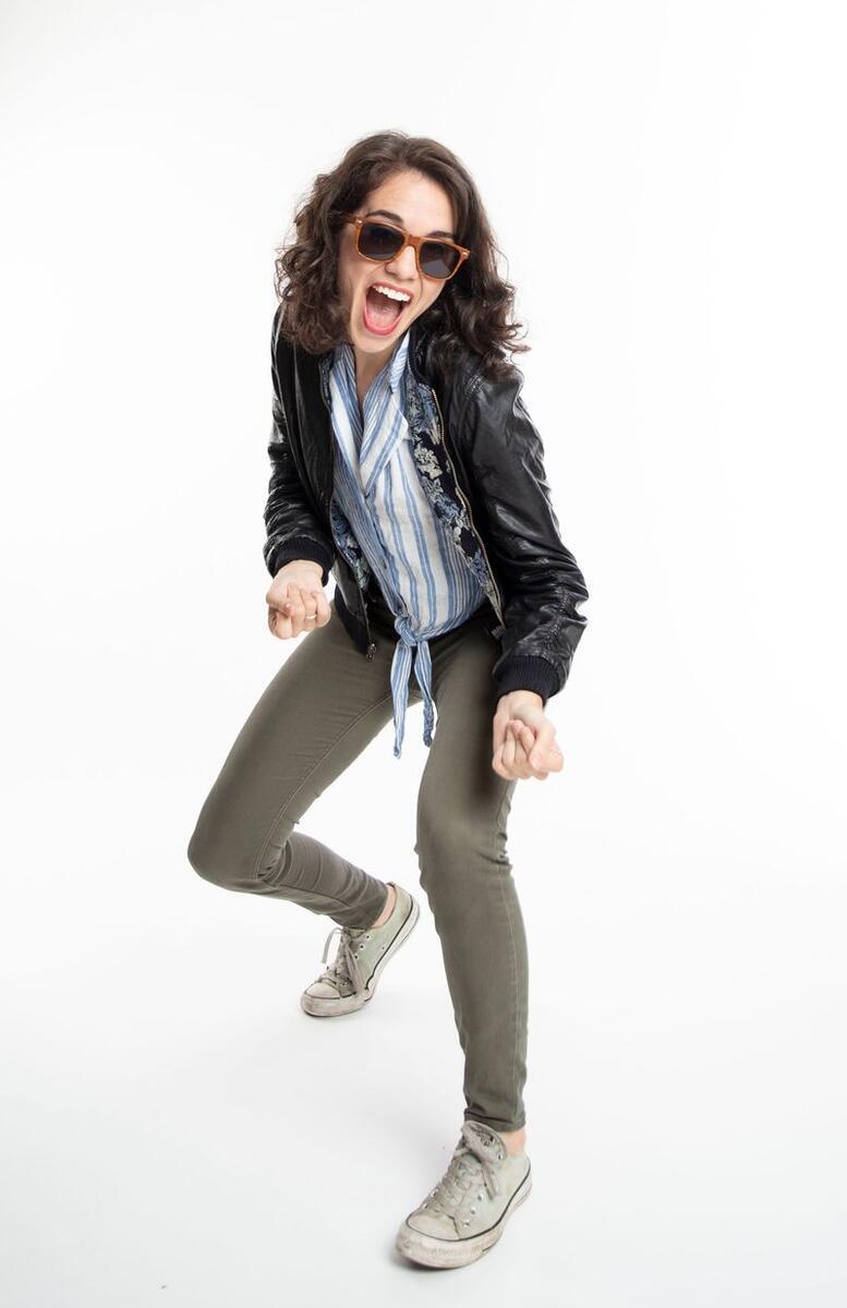 black and white photo of woman with brown hair and sun glasses dancing