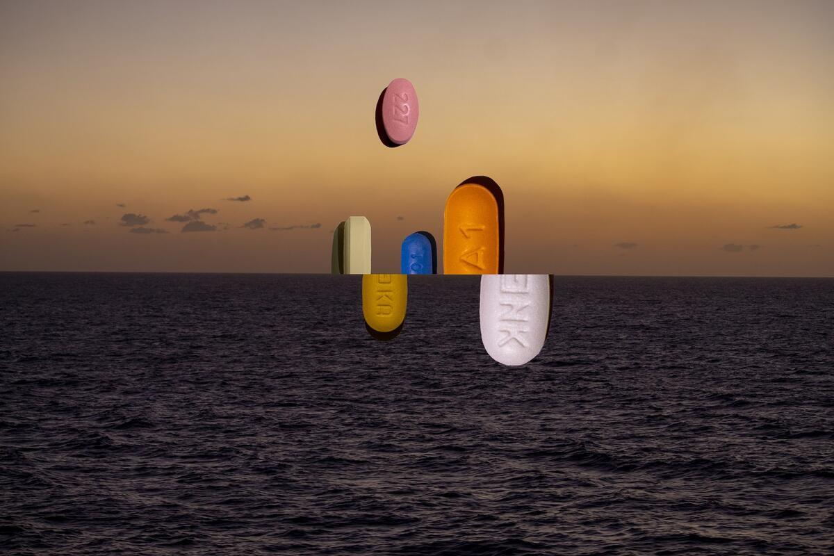 Collage of ocean landscape with magnified images of colorful pills on the horizon