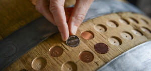 Coins placed into a band of wood with circular slots