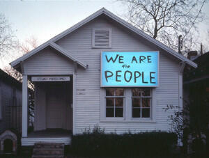 House with a neon blue sign saying "We are the people"