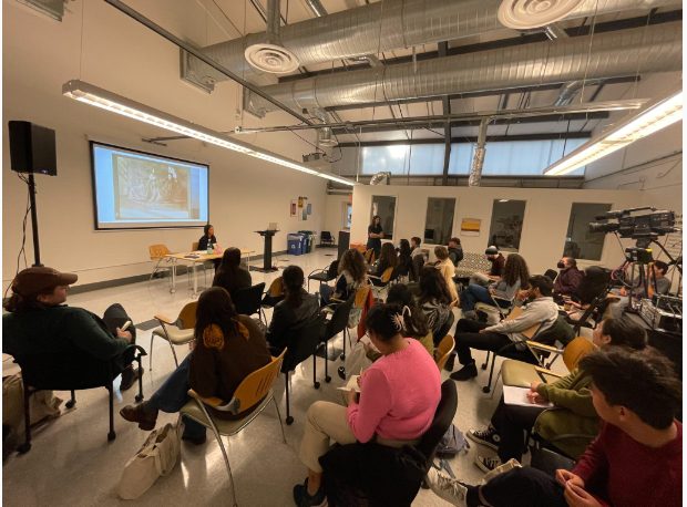 room of people watching a person speak