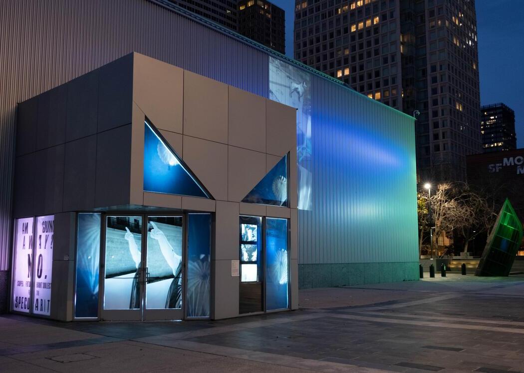 aluminum building with art of arms on windows and projected on building
