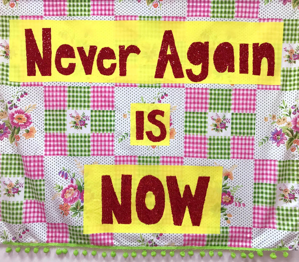 Flowery quilt featuring the words: "Never again is NOW"