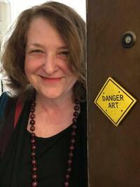 Person next to a door with a "DANGER ART" sign.