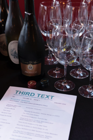 Wine bottles and glasses on a table with a magazine titled "THIRD TEXT."