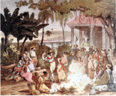 Outdoor gathering with people dancing and sitting around a fire near a colonial-style building, surrounded by trees and foliage.